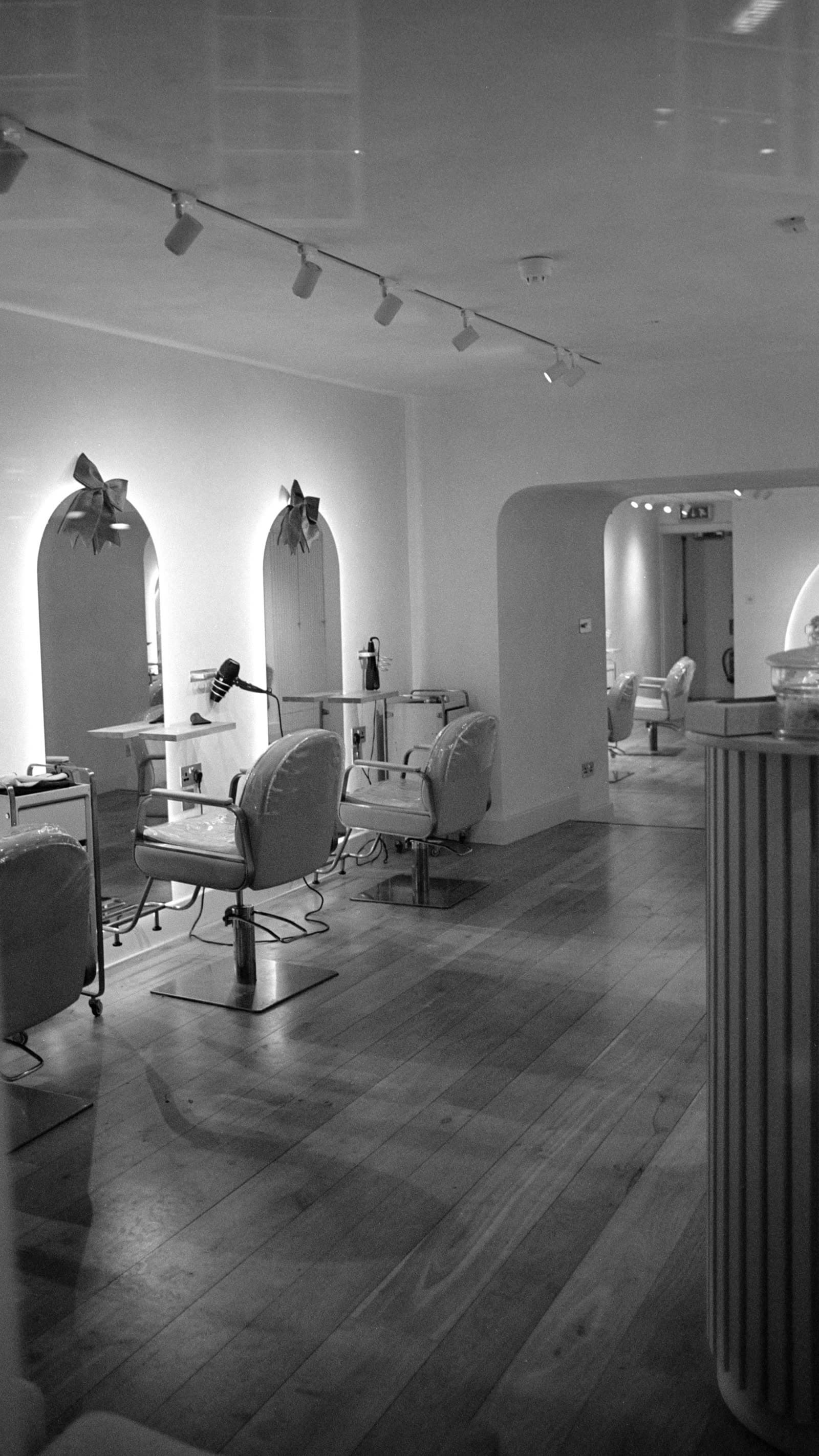 A hair salon interior with arched alcoves and styling chairs